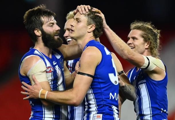 Charlie Comben of the Kangaroos is congratulated by team mates after kicking a goal during the round 22 AFL match between North Melbourne Kangaroos...