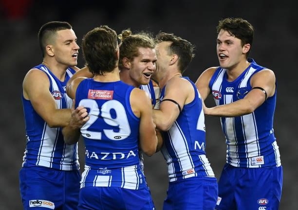 Jed Anderson of the Kangaroos is congratulated by team mates after kicking a goal during the round 22 AFL match between North Melbourne Kangaroos and...