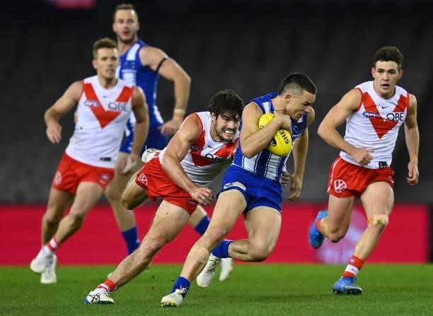 Luke Davies-Uniacke of the Kangaroos is tackled by George Hewett of the Swans during the round 22 AFL match between North Melbourne Kangaroos and...