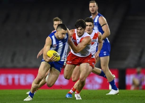Luke Davies-Uniacke of the Kangaroos is tackled by George Hewett of the Swans during the round 22 AFL match between North Melbourne Kangaroos and...
