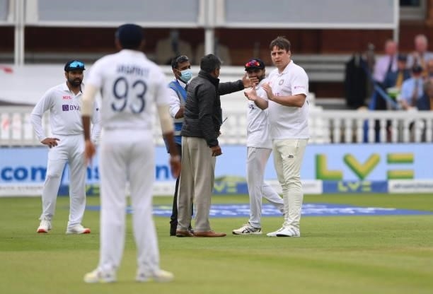 Spectator dressed in an India shirt and whites, makes his way onto the middle of the field before being escorted off before the afternoon session...