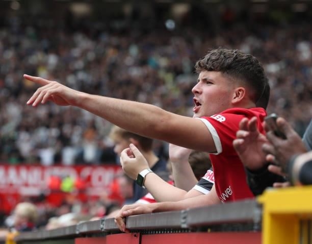 Manchester United fan watches from the stand during the Premier League match between Manchester United and Leeds United at Old Trafford on August 14,...
