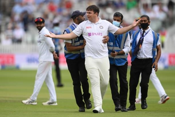 Pitch intruder is removed during the Second LV= Insurance Test Match: Day Three between England and India at Lord's Cricket Ground on August 14, 2021...