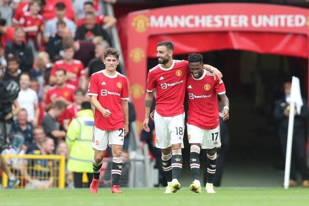 Fred of Manchester United celebrates with teammates Bruno Fernandes and Daniel James after scoring their side's fifth goal during the Premier League...