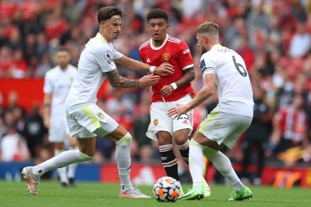Jadon Sancho of Manchester United passes the ball whilst under pressure from Robin Koch and Liam Cooper of Leeds United during the Premier League...