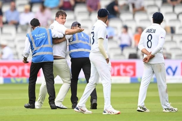 Pitch intruder dressed as a cricketer is escorted off the field during the third day of the 2nd LV= Test match between England and India at Lord's...