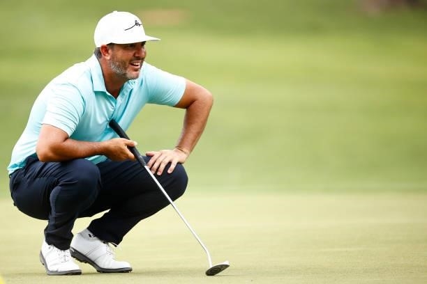 Scott Piercy of the United States lines up a putt on the seventh green during the third round of the Wyndham Championship at Sedgefield Country Club...
