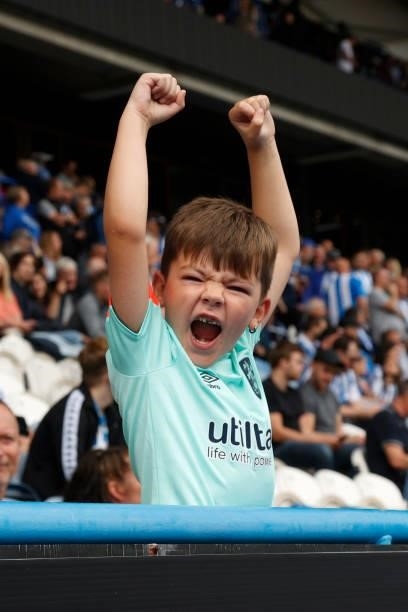 Young Town fan cheers on his team during the Sky Bet Championship match between Huddersfield Town and Fulham at Kirklees Stadium on August 14, 2021...