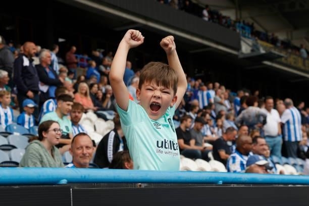 Young Town fan cheers on his team during the Sky Bet Championship match between Huddersfield Town and Fulham at Kirklees Stadium on August 14, 2021...