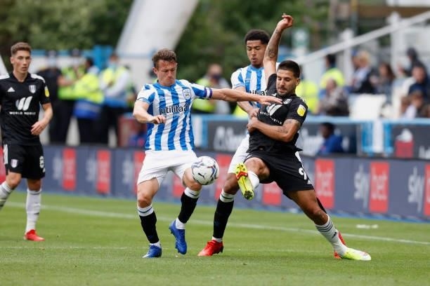 Jonathan Hogg and Levi Colwill of Huddersfield Town battle with Aleksandar Mitrović during the Sky Bet Championship match between Huddersfield Town...
