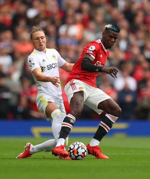 Luke Ayling of Leeds United battles with Paul Pogba of Manchester United during the Premier League match between Manchester United and Leeds United...