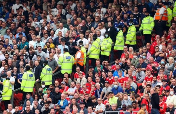 Stewards form a line between the Leeds United and Manchester United fans during the Premier League match between Manchester United and Leeds United...