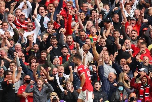 Fans celebrate after Bruno Fernandes of Manchester United scores the first goal during the Premier League match between Manchester United and Leeds...