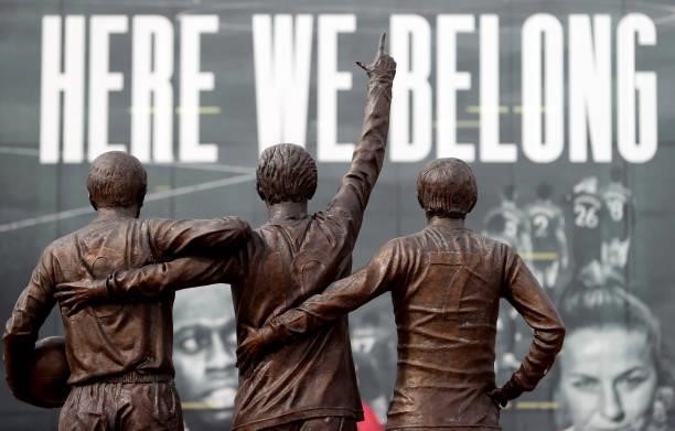 View of the Holy Trinity statue of Sir Bobby Charlton, Denis Law and George Best infront a sign saying ' here we belong 'outside the stadium prior to...