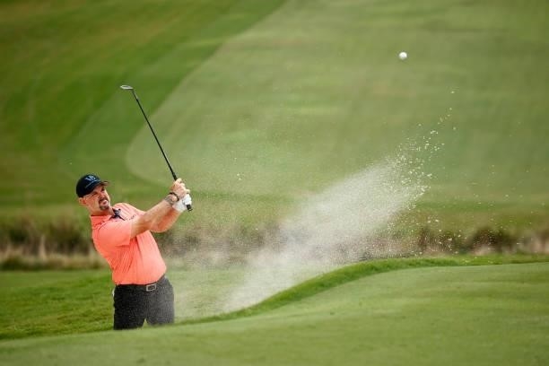 Rory Sabbatini of Slovakia plays a shot from a greenside bunker on the 18th hole during the third round of the Wyndham Championship at Sedgefield...