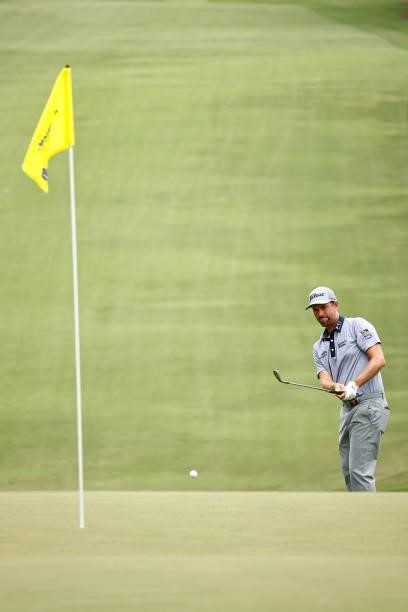 Webb Simpson of the United States attempts to chip to the 18th green during the third round of the Wyndham Championship at Sedgefield Country Club on...