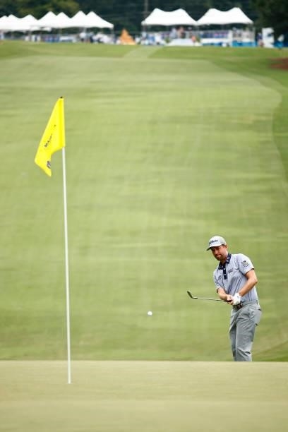 Webb Simpson of the United States attempts to chip to the 18th green during the third round of the Wyndham Championship at Sedgefield Country Club on...
