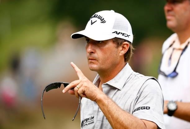 Kevin Kisner of the United States signals as he walks off the 18th green during the third round of the Wyndham Championship at Sedgefield Country...