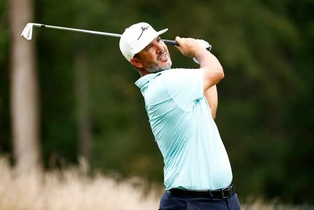 Scott Piercy of the United States plays his shot from the 12th tee during the third round of the Wyndham Championship at Sedgefield Country Club on...