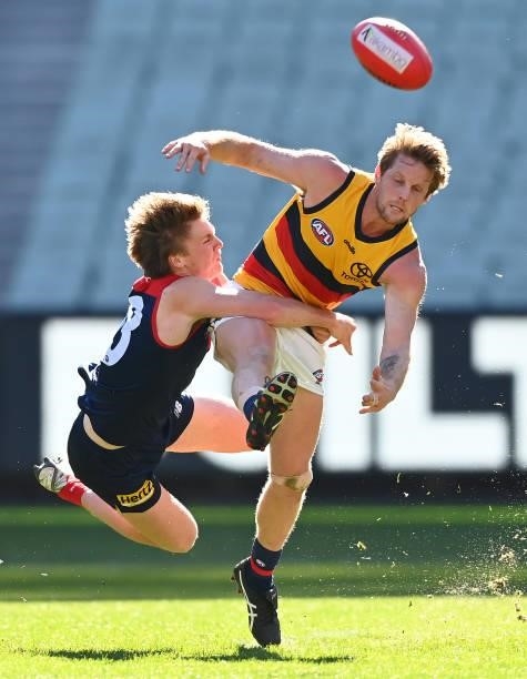 Rory Sloane of the Crows kicks whilst being tackled by James Jordan of the Demons during the round 22 AFL match between Melbourne Demons and Adelaide...