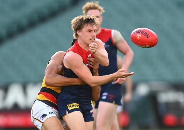 Charlie Spargo of the Demons handballs whilst being tackled during the round 22 AFL match between Melbourne Demons and Adelaide Crows at Melbourne...