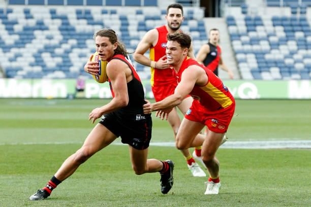 Archie Perkins of the Bombers runs with the ball the ball during the round 22 AFL match between Gold Coast Suns and Essendon Bombers at GMHBA Stadium...