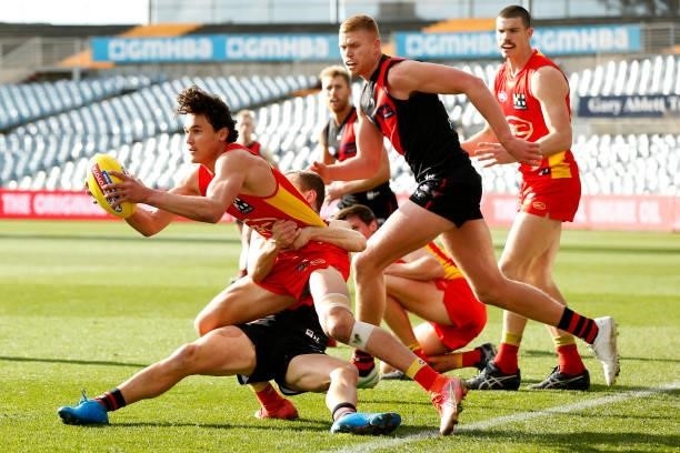 Wil Powell of the Suns is tackled during the round 22 AFL match between Gold Coast Suns and Essendon Bombers at GMHBA Stadium on August 15, 2021 in...