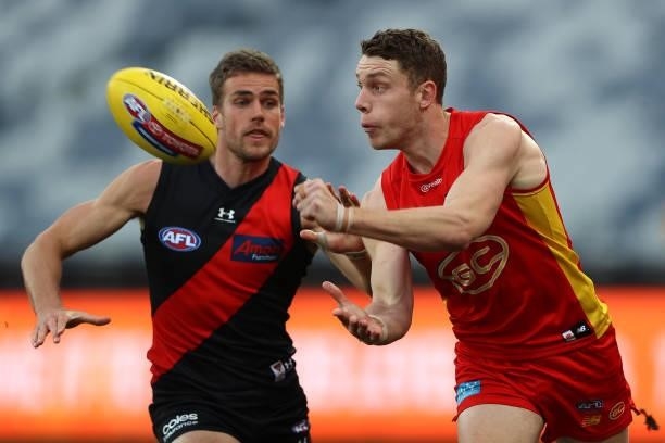 Josh Corbett of the Suns handballs during the round 22 AFL match between Gold Coast Suns and Essendon Bombers at GMHBA Stadium on August 15, 2021 in...