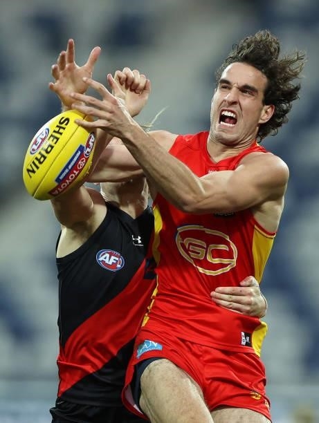 Ben King of the Suns is challenged by Mason Redman of the Bombers during the round 22 AFL match between Gold Coast Suns and Essendon Bombers at GMHBA...
