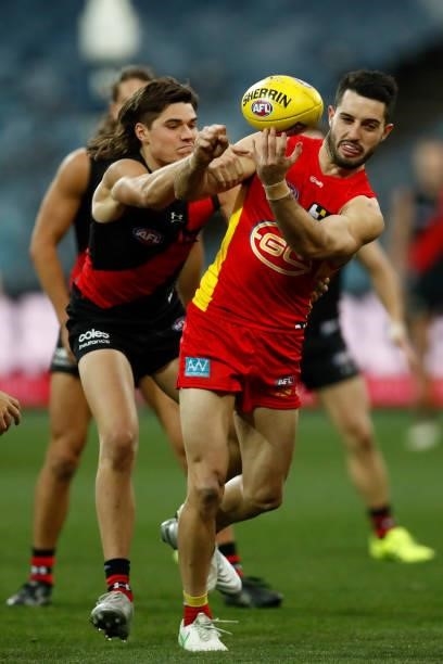 Brayden Fiorini of the Suns handballs during the round 22 AFL match between Gold Coast Suns and Essendon Bombers at GMHBA Stadium on August 15, 2021...