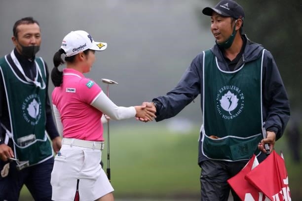 Sakura Koiwai of Japan shakes hands with her caddie after winning the tournament on the 18th green during the final round of the NEC Karuizawa 72...