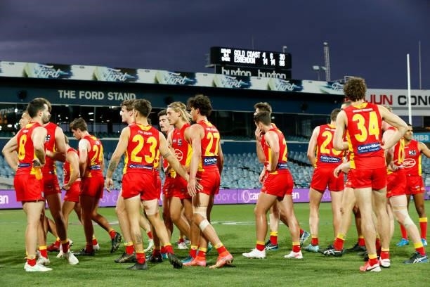 Dejected Gold Coast Suns players walk from the ground after the round 22 AFL match between Gold Coast Suns and Essendon Bombers at GMHBA Stadium on...