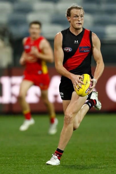 Mason Redman of the Bombers runs with the ball during the round 22 AFL match between Gold Coast Suns and Essendon Bombers at GMHBA Stadium on August...