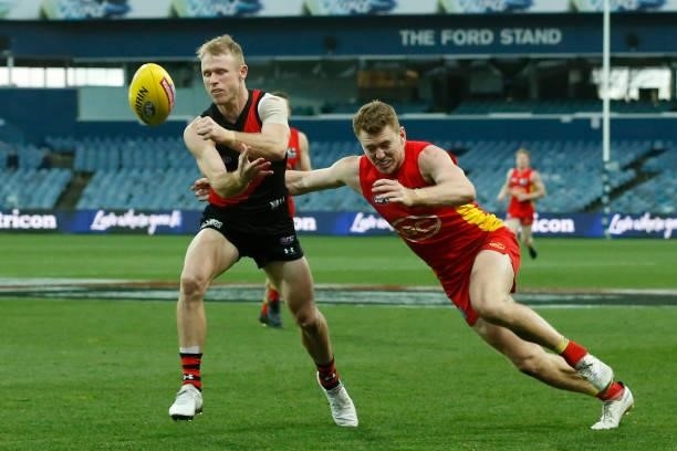 Nick Hind of the Bombers handballs during the round 22 AFL match between Gold Coast Suns and Essendon Bombers at GMHBA Stadium on August 15, 2021 in...