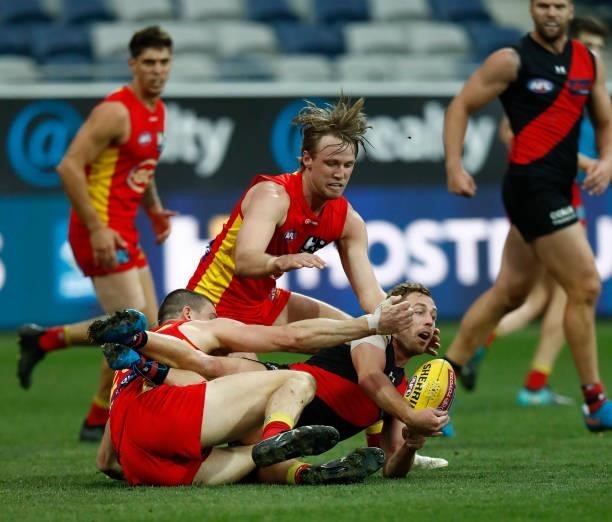 Devon Smith of the Bombers handballs during the round 22 AFL match between Gold Coast Suns and Essendon Bombers at GMHBA Stadium on August 15, 2021...