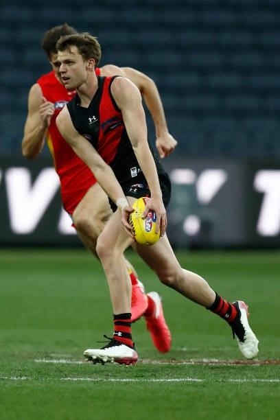 Jordan Ridley of the Bombers runs with the ball during the round 22 AFL match between Gold Coast Suns and Essendon Bombers at GMHBA Stadium on August...