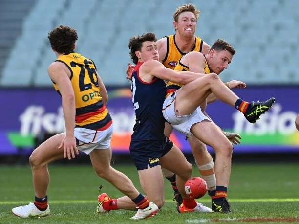 Rory Laird of the Crows kicks whilst being tackled by Tom Sparrow of the Demons during the round 22 AFL match between Melbourne Demons and Adelaide...
