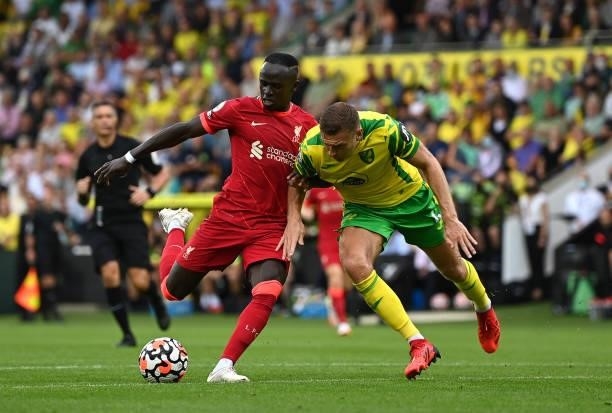 Sadio Mane of Liverpool is challenged by Ben Gibson of Norwich City during the Premier League match between Norwich City and Liverpool at Carrow Road...