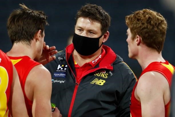 Stuart Dew, senior coach of the Suns speaks to David Swallow and Matt Rowell of the Suns during the round 22 AFL match between Gold Coast Suns and...