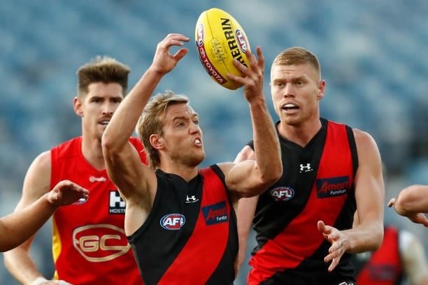 Darcy Parish of the Bombers handballs during the round 22 AFL match between Gold Coast Suns and Essendon Bombers at GMHBA Stadium on August 15, 2021...
