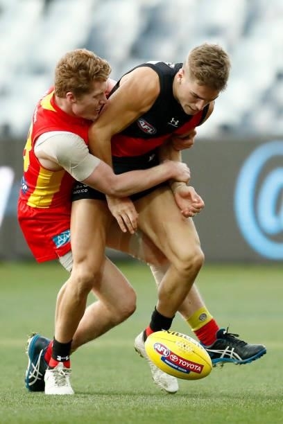 Matt Rowell of the Suns tackles Matt Guelfi of the Bombers during the round 22 AFL match between Gold Coast Suns and Essendon Bombers at GMHBA...