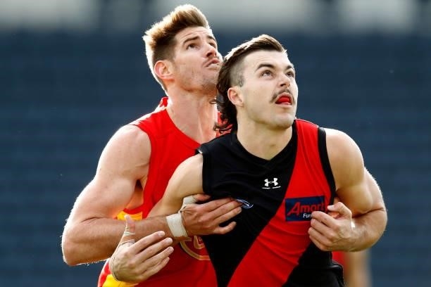 Zac Smith of the Suns and Sam Draper of the Bombers compete during the round 22 AFL match between Gold Coast Suns and Essendon Bombers at GMHBA...