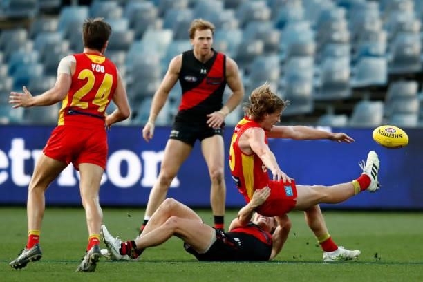 Mason Redman of the Bombers tackles Noah Anderson of the Suns during the round 22 AFL match between Gold Coast Suns and Essendon Bombers at GMHBA...