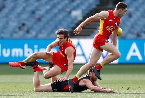 Ben King of the Suns avoids giving away a free kick to Jayden Laverde of Bombers during the round 22 AFL match between Gold Coast Suns and Essendon...