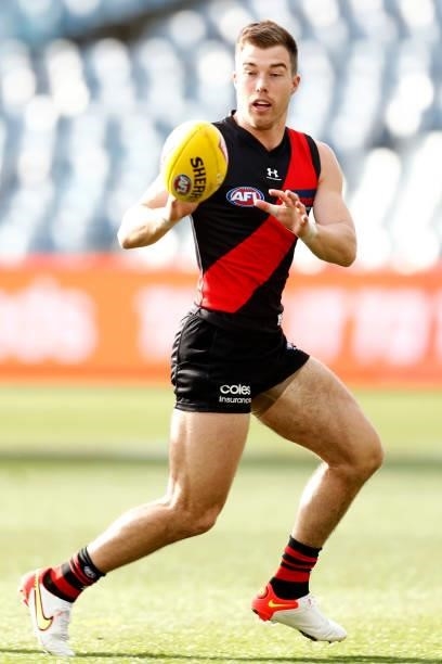 Zach Merrett of the Bombers gathers the ball during the round 22 AFL match between Gold Coast Suns and Essendon Bombers at GMHBA Stadium on August...