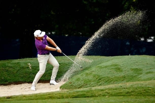 John Augenstein of the United States plays a shot from a bunker on the first hole during the final round of the Wyndham Championship at Sedgefield...