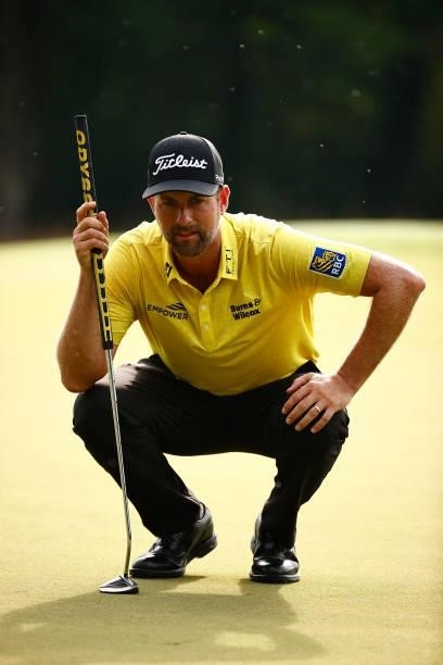 Webb Simpson of the United States lines up a putt on the first green during the final round of the Wyndham Championship at Sedgefield Country Club on...