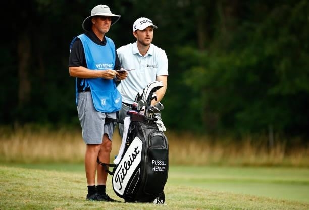 Russell Henley of the United States waits with caddie Todd Gjesvold on the second fairway during the final round of the Wyndham Championship at...