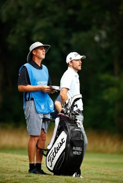 Russell Henley of the United States waits with caddie Todd Gjesvold on the second fairway during the final round of the Wyndham Championship at...