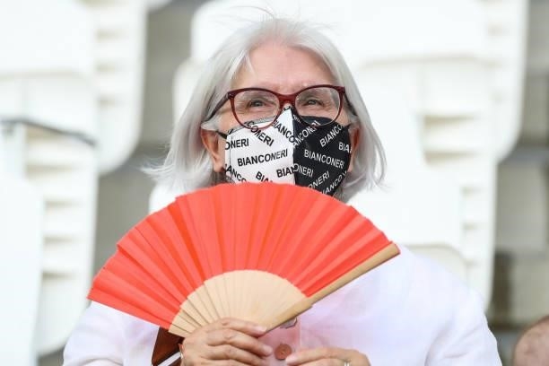 Female Juventus fan with a branded face mask attempts to keep cool in the scorching temperature with a fan during the Pre-Season Friendly between...